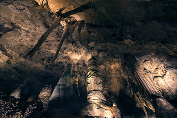 huge stalactites, stalagmites, and columns in a giant cave room 