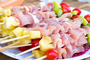 A lot of pork meat was made barbecue with chili pepper, tomato and pineapple for dinner party at backyard