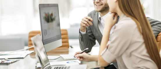  Manager and accountant are sitting and discussing financial charts with the profits of the company...