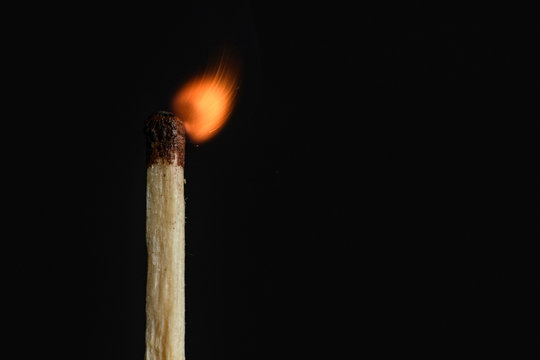 The time of the decay of the dying match flames on a black background closeup