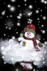 cute toy snowman on a black background