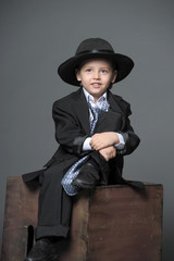 Boy in suit and hat.