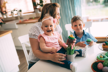 Happy easter. A mother and her kids painting Easter eggs