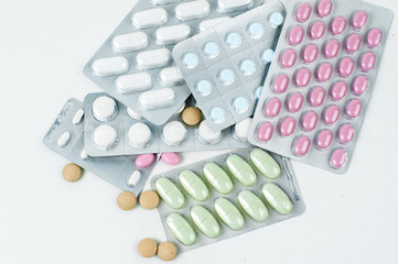 Assorted packs of pharmaceutical medicine pills and capsules.