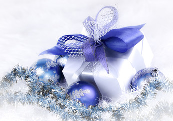 Fototapeta na wymiar Christmas gift and blue Christmas balls on a festive white back
