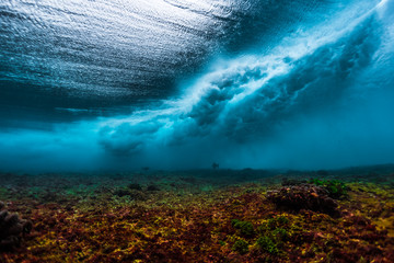Underwater view of the surf spot with wave breaking over coral reef