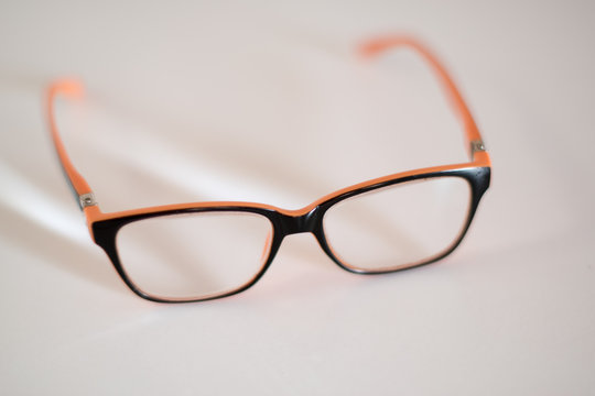 glasses in an orange frame on a white background. Selective focus. Close up