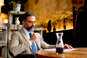 Handsome man drinking red wine during lunch