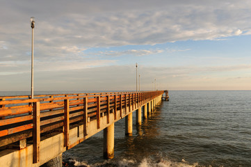 Naklejka premium Pier on the beach, sunset