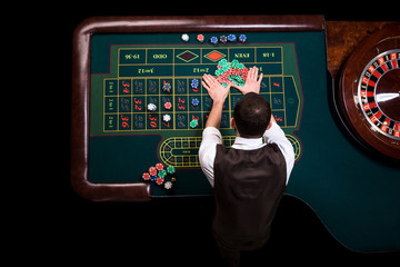 Top view of the casino croupier and the green roulette table. Ga