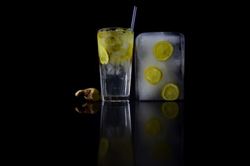 Cocktails with ice cube in glass isolated on black.