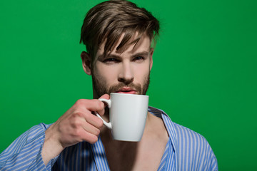 Man with cup on green background