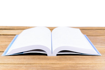 The open book is placed on a wooden table in white background or isolated
