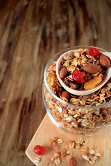 Granola in a glass jar and wooden spoon. Rustic style
