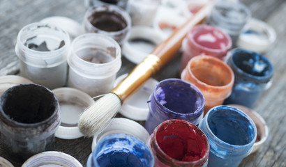 brush and colored water paints on a wooden table