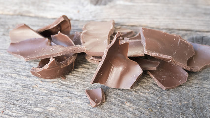 Crushed dark chocolate on old wooden table