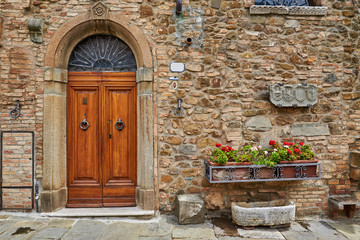 Flowery streets on spring day in a small magical village Pienza, Tuscany.
