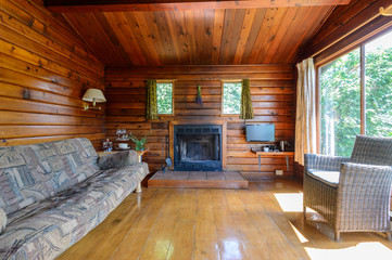 Fototapeta na wymiar Cozy interior of a rustic log cabin with a fireplace.