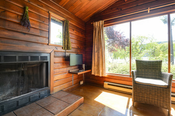 Fototapeta na wymiar Cozy interior of a rustic log cabin with a view of a garden.