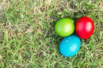 Colorful easter eggs on green grass. Top view with copy space.