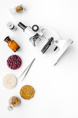 Fototapeta na wymiar Food safety. Wheat, rice and red beans near microscope on white background top view copy space