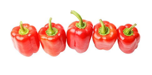 Five ripe red sweet peppers in the row isolated on white. Angle view.