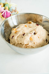 Raw dough with raisins for buns. Easter baking.