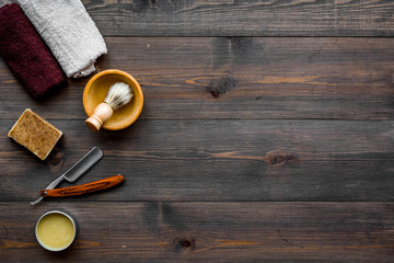 Men's shaving. Razor and brush on dark wooden background top view copy space
