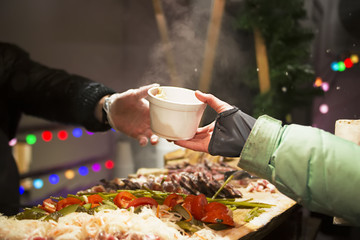 the cook pours the broth into the cups. Cooking food on the street