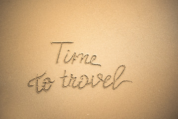 Time to Travel word is written on the beach sand