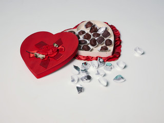 Open heart shape box of chocolates, white background 