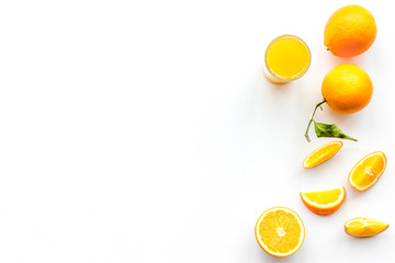 Orange juice in glass near slices of oranges on white background top view copy space