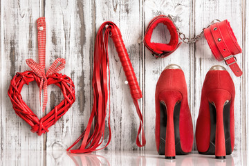 red shoes lash heart handcuffs on a wooden background