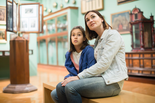 Young mom and daughter looking at expositions