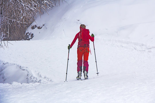 Woman with skis walk by snow on the mountain