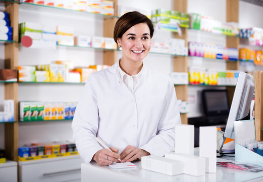 female pharmacist checking assortment of drugs in pharmacy