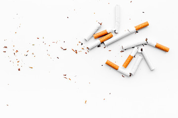 Smoking. Half-smoked cigarettes with ash on white background top view copy space