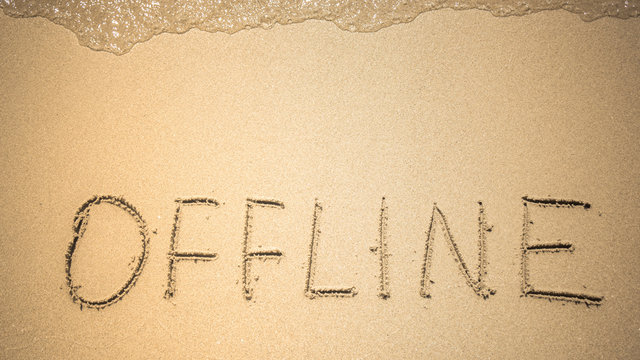 Offline word is written on the beach sand