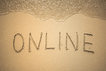 Online word is written on the beach sand