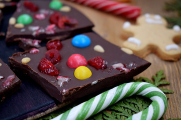 Dark chocolate bark with multicoloured drops, nuts and dried fruits broken into pieces