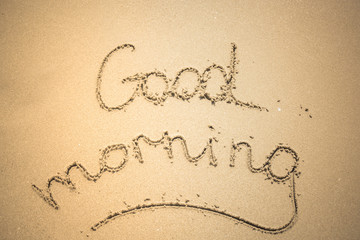 Good Morning word is written on the beach sand
