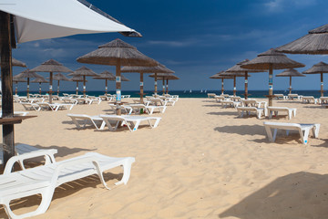 Rows of sun loungers and umbrellas on the beach.Tavira, Portugal