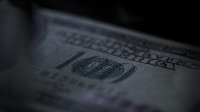 Elements and signs on a 100 banknote: a portrait of the president, a figure of par value. Scanning a banknote with ultraviolet light: a green beam moves along the banknote. Check for counterfeit bill