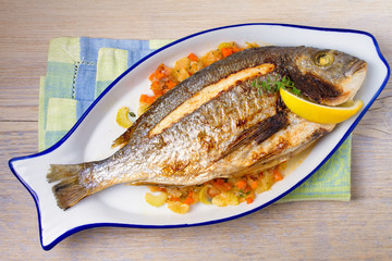 Whole dorado or dorada fish with vegetables, thyme and lemon. View from above, top, horizontal