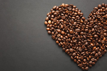 Brown coffee beans in form of heart isolated on black texture background for design, part or half. Saint Valentine's Day card on fabruary 14, holiday concept.