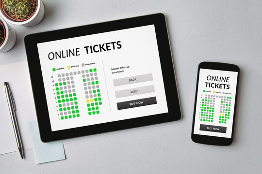 Online tickets concept on tablet and smartphone screen over gray table. All screen content is designed by me. Flat lay