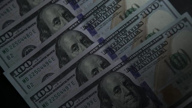 American Dollars: banknote 100. President Benjamin Franklin on a bill. Several banknotes with a face value of 100, ray of light is moving along them. Bank and money. Monetary system of the country.