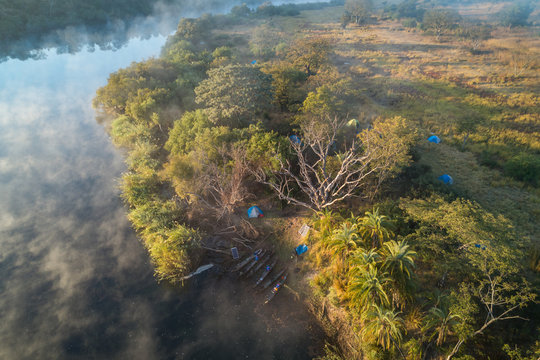 Acampados nas margens do rio Cubango de madrugada. Visto do ar com drone. Angola