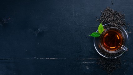 A cup of black tea on a wooden background. Top view. Copy space.
