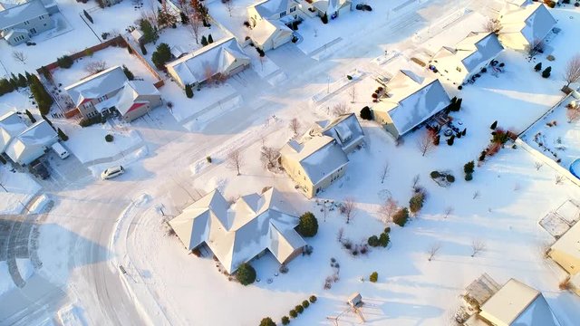 Beautiful neighborhoods in the grip of Winter, homes frozen under snow and ice, aerial view.